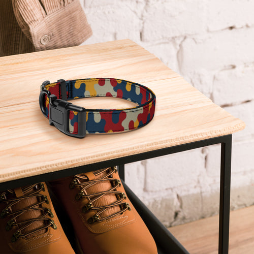 Colorful patterned dog collar on a wooden table with brown shoes underneath.