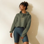 Woman wearing a green hoodie and dark blue shorts against a plain background