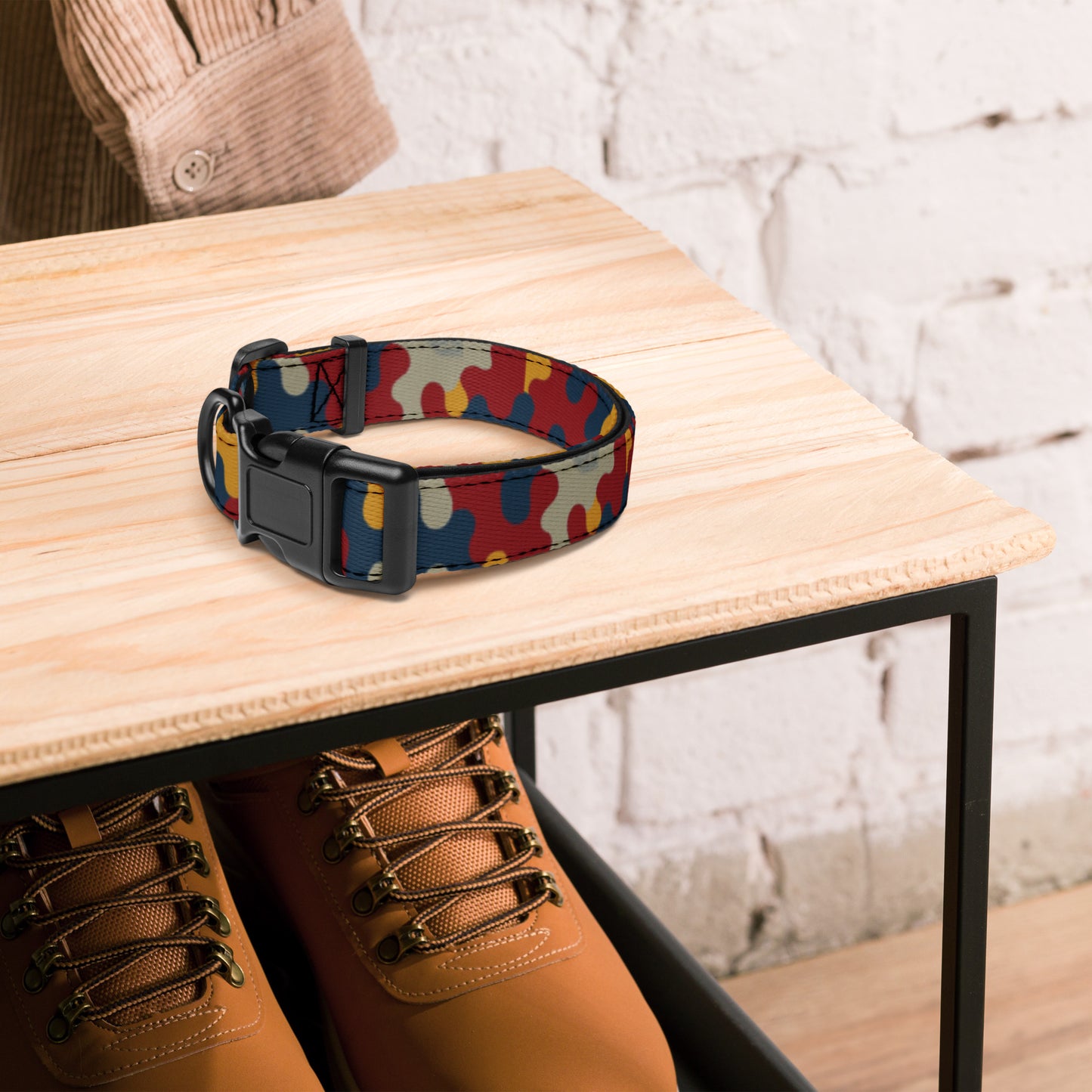 Colorful dog collar on a wooden table with brown shoes underneath.